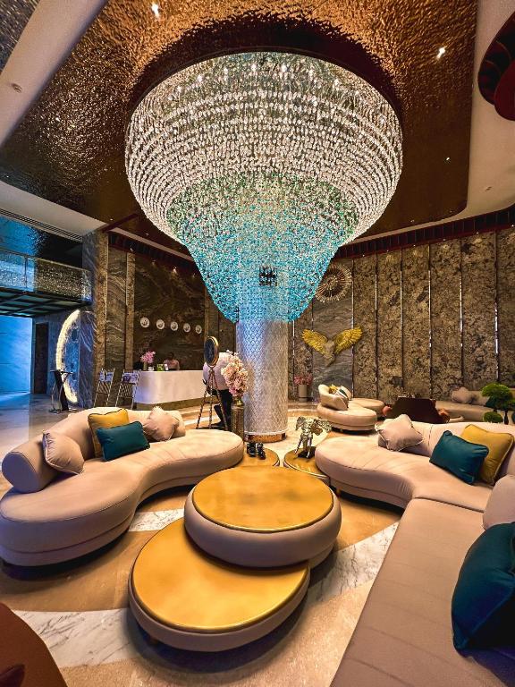 a large chandelier in a room with couches and a large ceiling at Hotel Imperial Blu in Similigurha