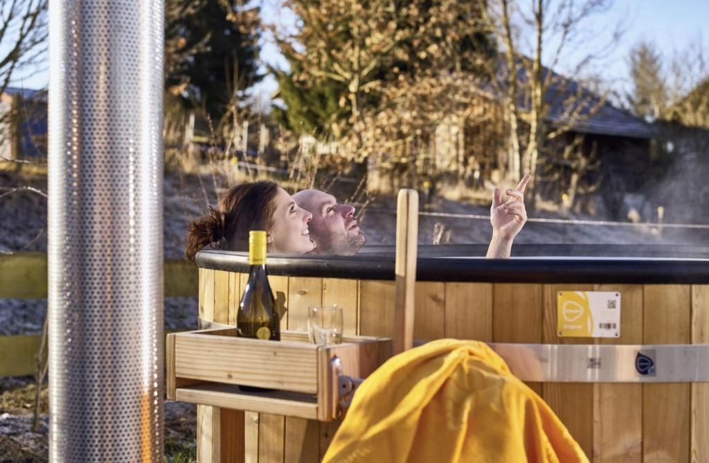 a man and a woman laying in a hot tub at Stern Romantik am Hof in Kollnburg