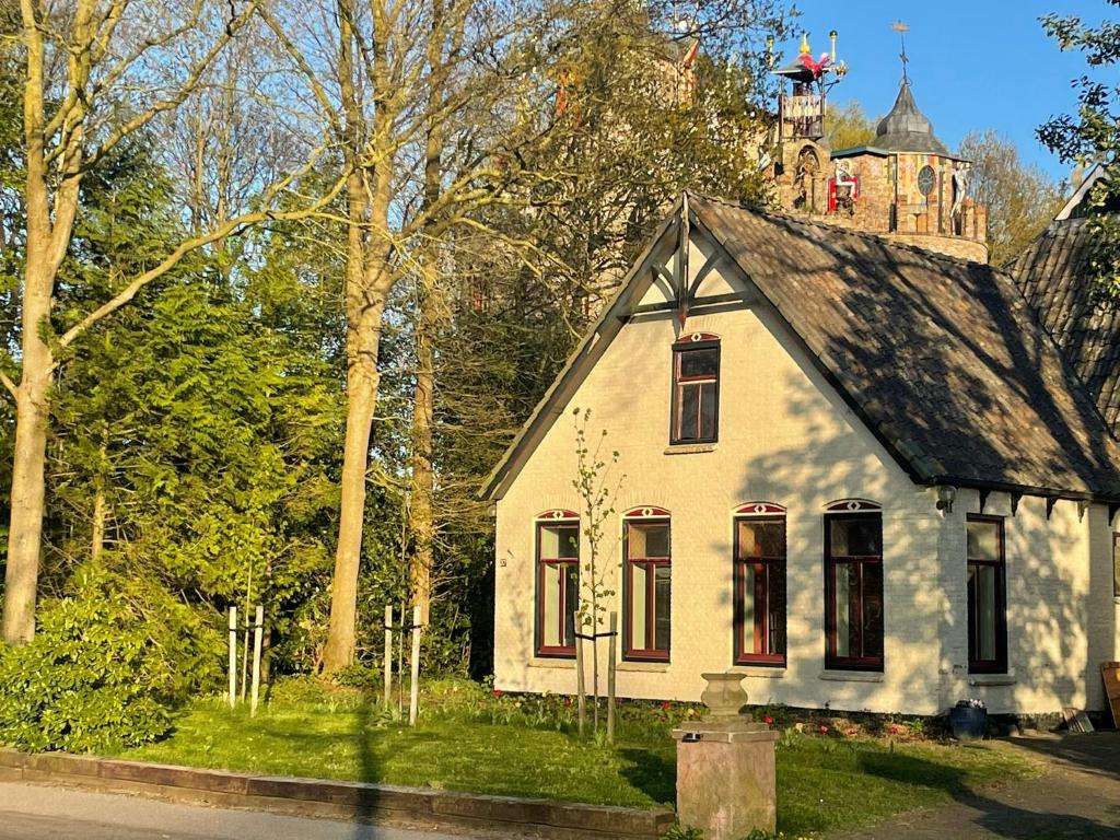 a small white house with a tower on top of it at B&B huize Stoutenburght in Blesdijke