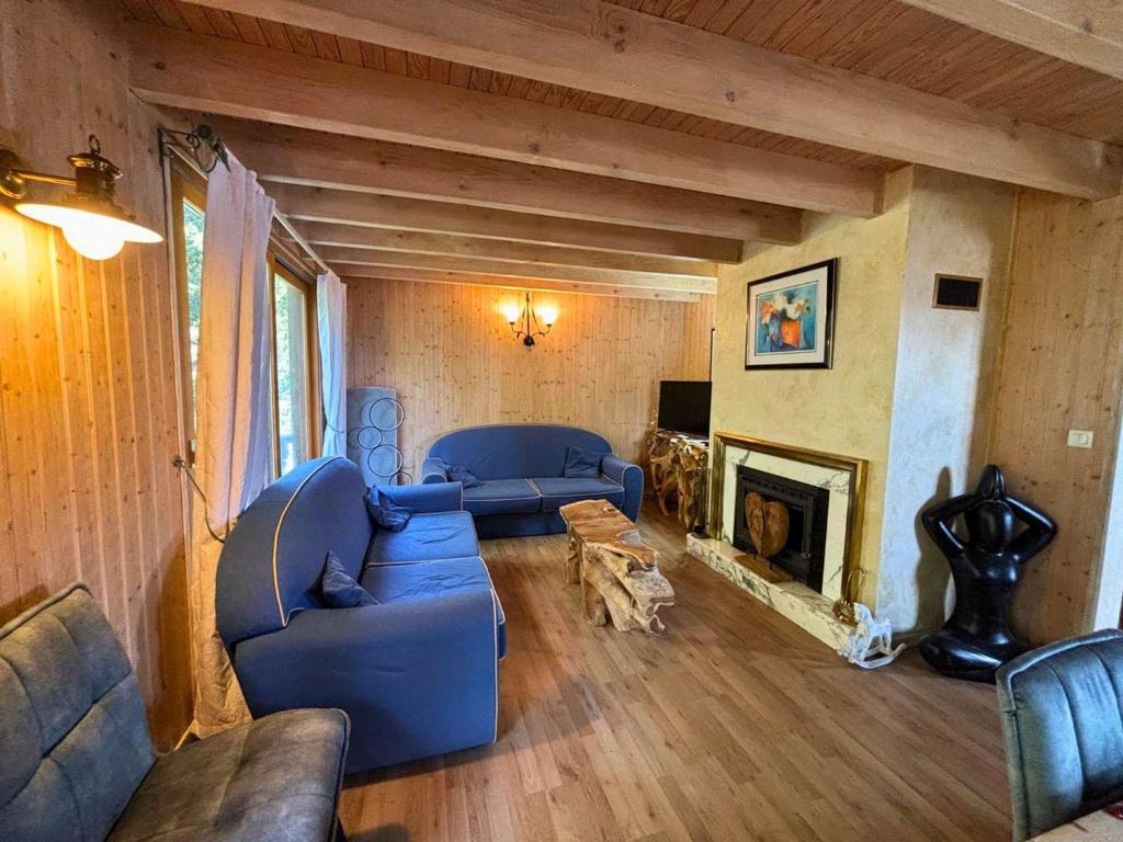 a living room with blue couches and a fireplace at CONFORTABLE CHALET INDIVIDUEL SUR PYRENEES 2000 in Font-Romeu