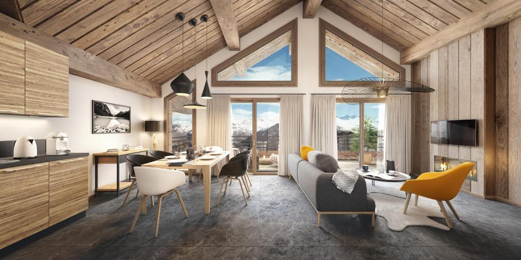 a kitchen and a living room with a table and chairs at TERRESENS Le Caprice Blanc in La Toussuire