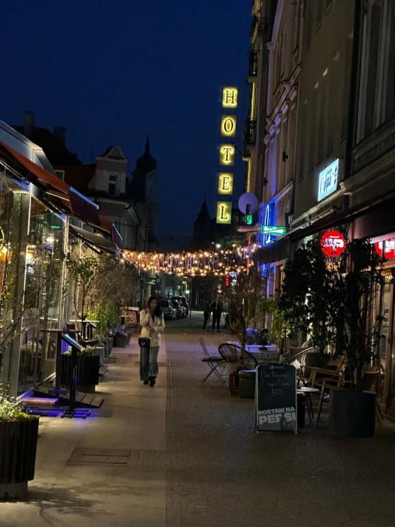 a person riding a bike down a street at night at Hotel Polonia in Ostrów Wielkopolski