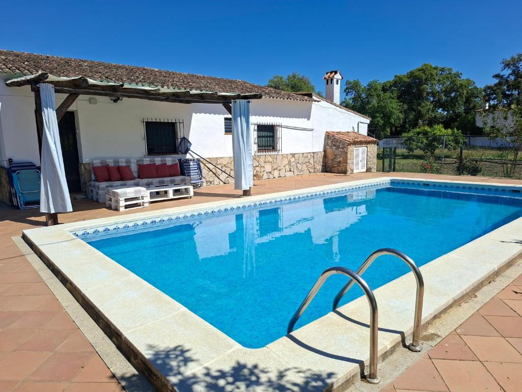 a swimming pool in front of a house at Huerta del Sol in Aracena