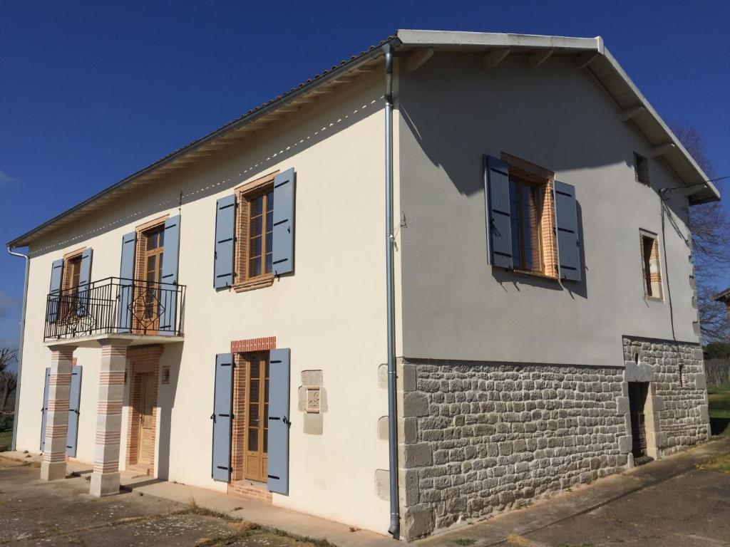 a white house with brown shuttered windows at Les Blancs - Maison de maître entourée de vignes in Lisle-sur-Tarn