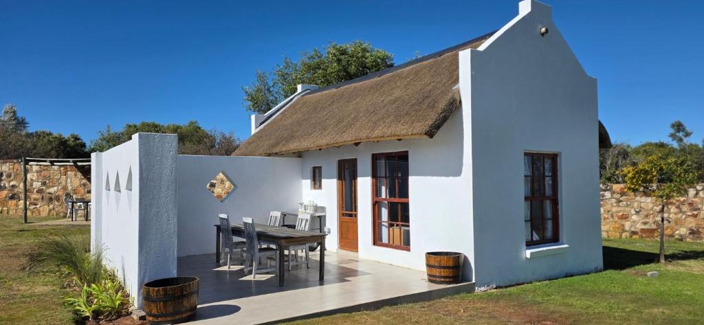 a small white house with a table and chairs at Mooring Manor Chalet in Vaal Marina