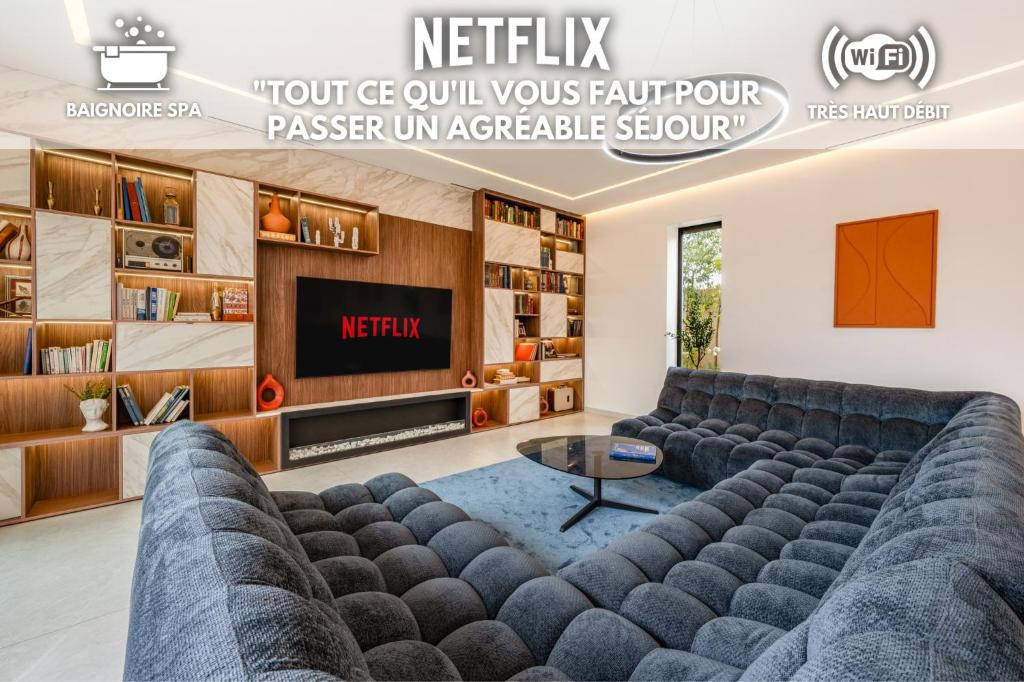a living room with a couch and a tv at Villa Gaspard - Piscine et jardin Privée Sans vis-à-vis Wifi HD in Marrakesh