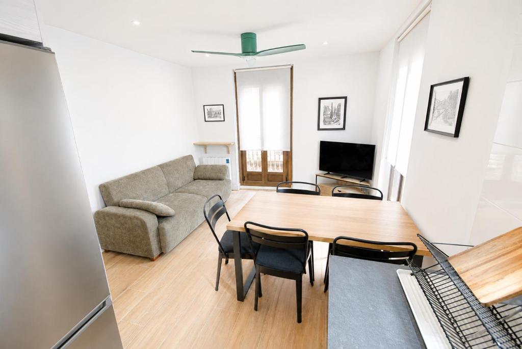 a living room with a table and chairs and a couch at Apartaments Angelina in La Pobla de Segur