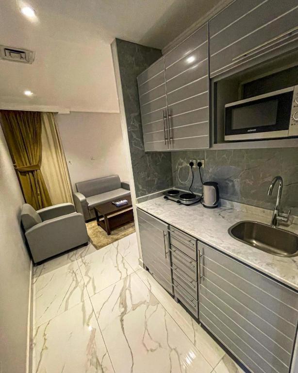 a small kitchen with a sink and a microwave at Continental Hotel & Suite in Kuwait