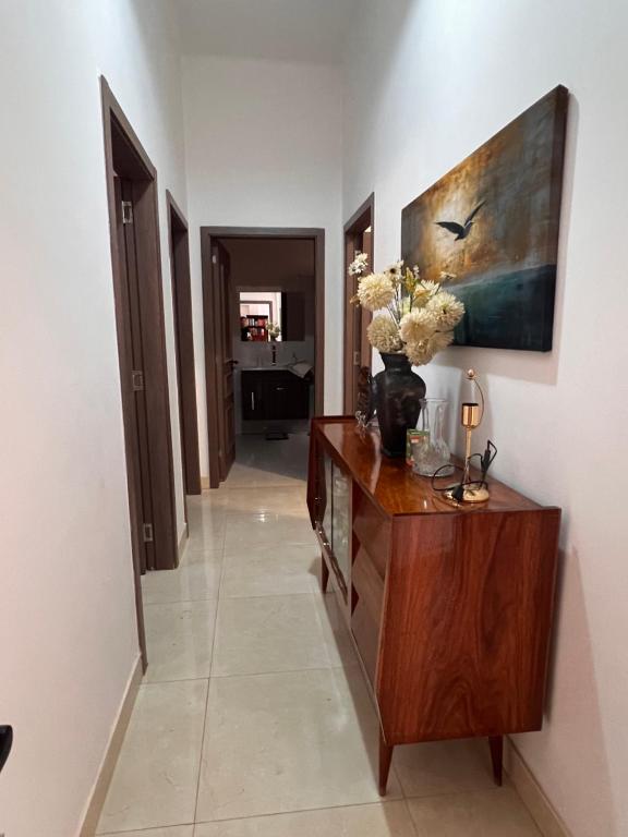 a hallway with a dresser with a vase of flowers on it at Casa Tolentino in Bissau