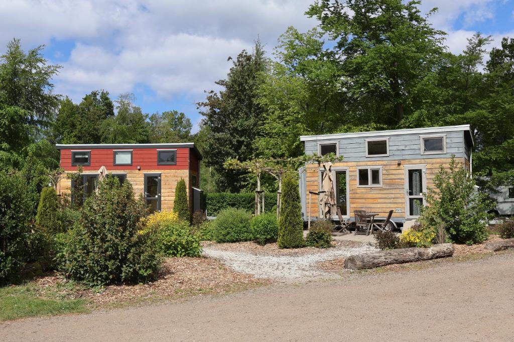 ein Minihaus und ein Wohnwagen in einem Garten in der Unterkunft Vakantiepark 't Urkerbos -Tiny house in Urk