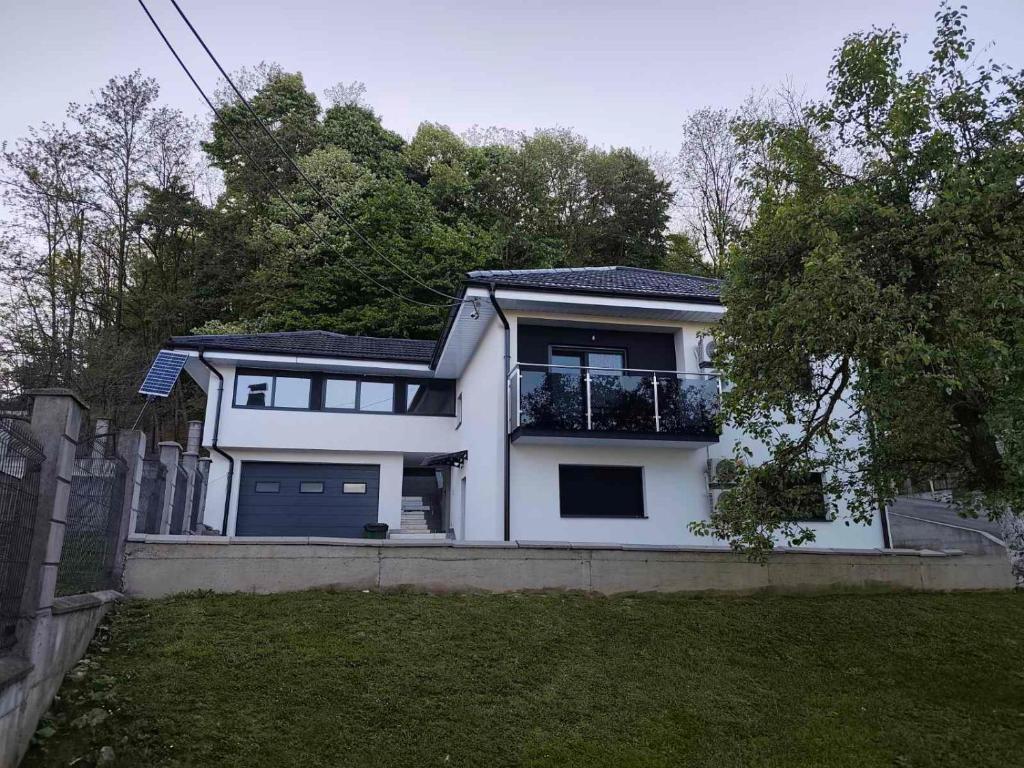 a white house with a fence and a yard at Apartman Florida ranč in Doboj