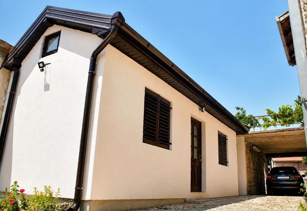 a white house with a black roof at Balkan House in Mostar