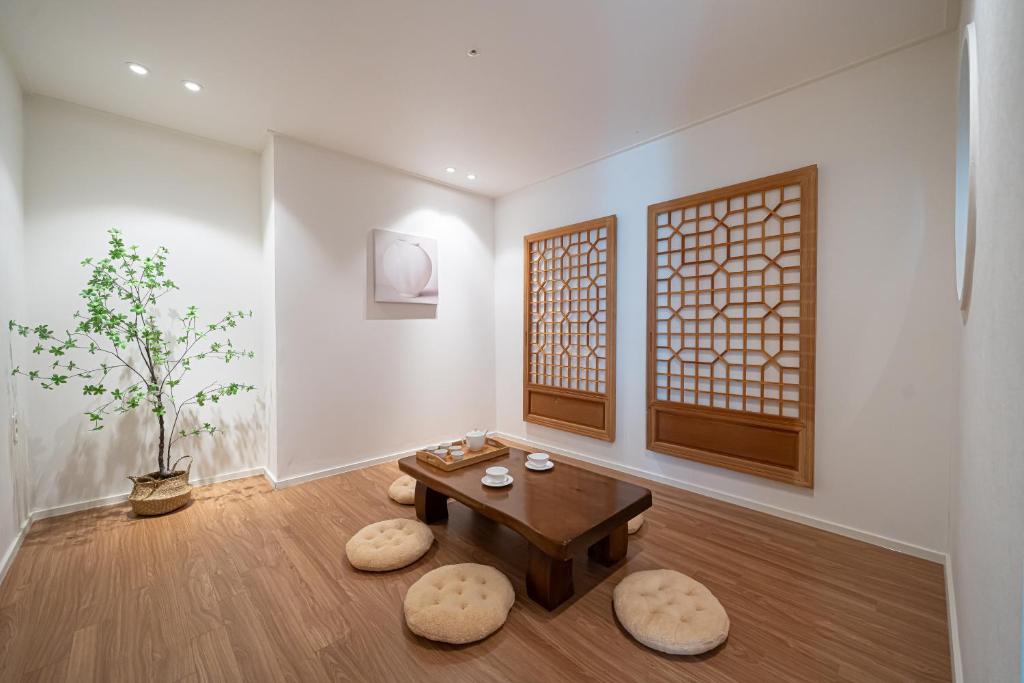a living room with a table and two stools at Hotel Whooahan Suyu in Seoul