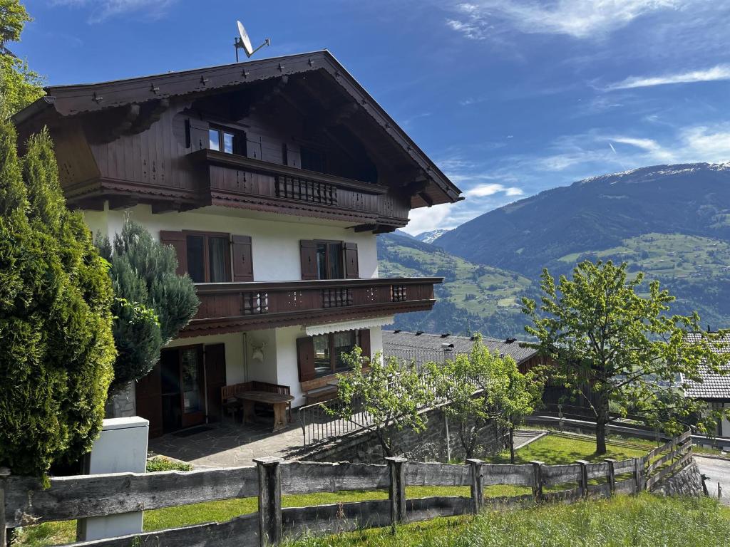 a house in the mountains with a fence at Ferienhaus Riedberg in Ried im Zillertal