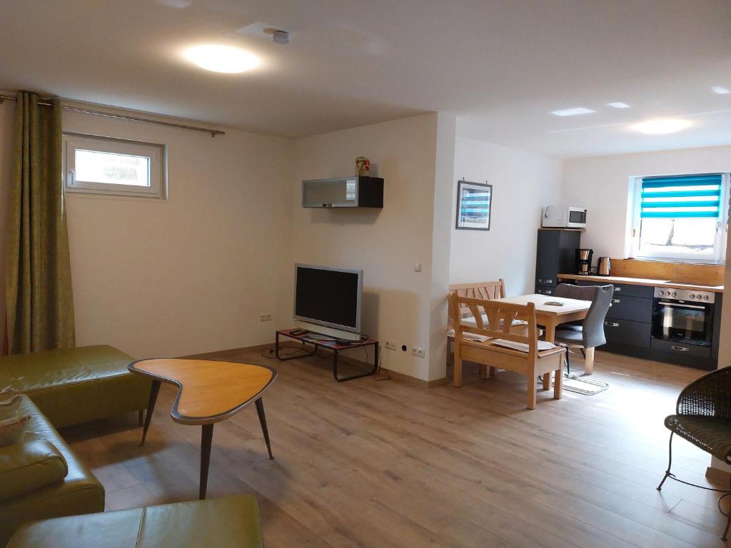 a living room with a couch and a table at Ferienwohnung Gartenweg in Strullendorf
