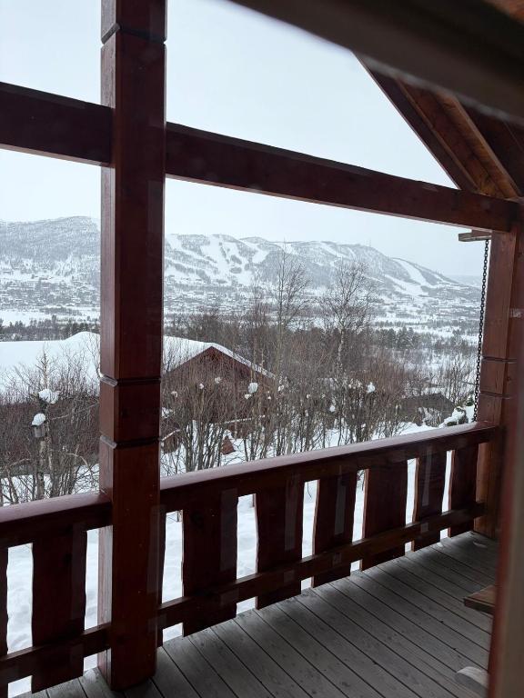 a view of a snowy mountain from a wooden deck at Bakkestølveien 360 in Hol