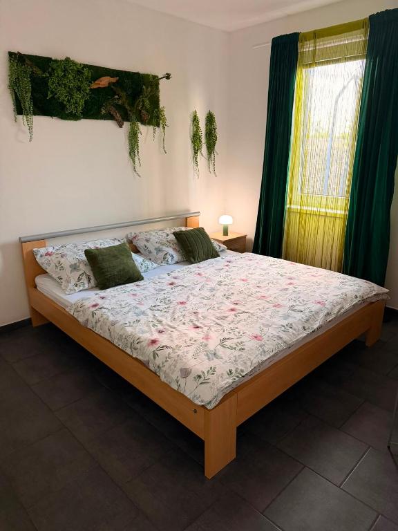 a bedroom with a large bed with green curtains at Apartmány KK in Chvalovice
