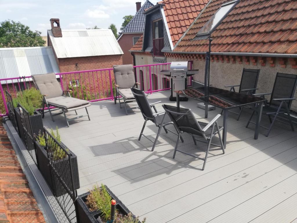 a deck with chairs and a table and a grill at Wittenburg Perdöhl 2 in Wittenburg
