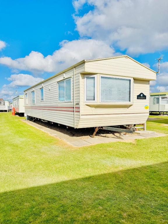 a mobile home is parked in a grass field at 6 Birth Cosy caravan 134 Sealands in Ingoldmells