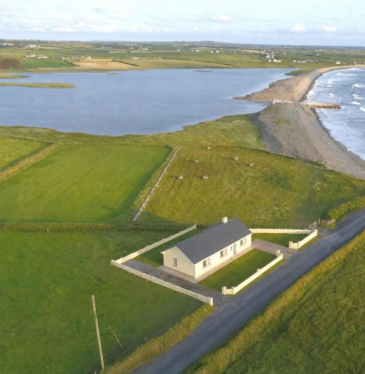 an aerial view of a house next to a body of water at Beach Side House in Quilty in Quilty