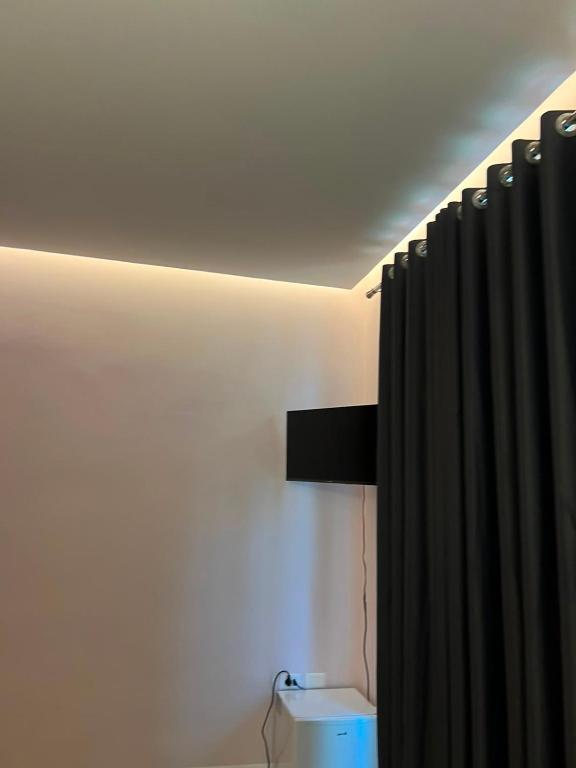 a bathroom with a black shower curtain and a ceiling at Gwin Hotel in Fier
