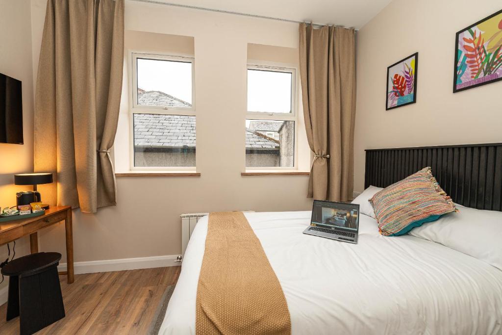 a bedroom with a bed with a laptop on it at Wee Sleep Ireland in Derry Londonderry