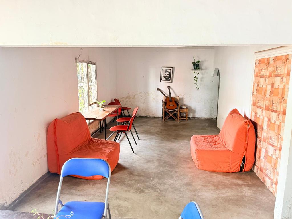 a living room with orange chairs and a table at Bed Station Negombo in Negombo