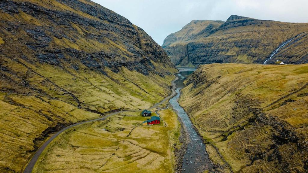 an aerial view of a river in a mountain at Saksun Mountain & Beach Cottage in Saksun