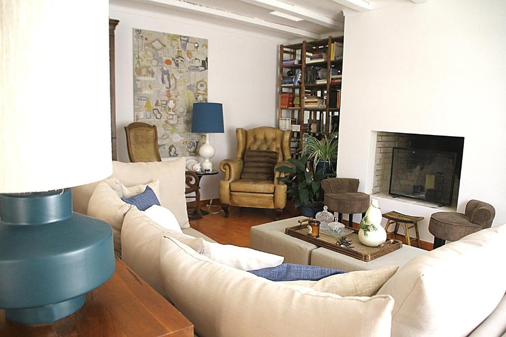a living room with white furniture and a fireplace at Senhora do Cabo Meco Homy Holidays in Sesimbra