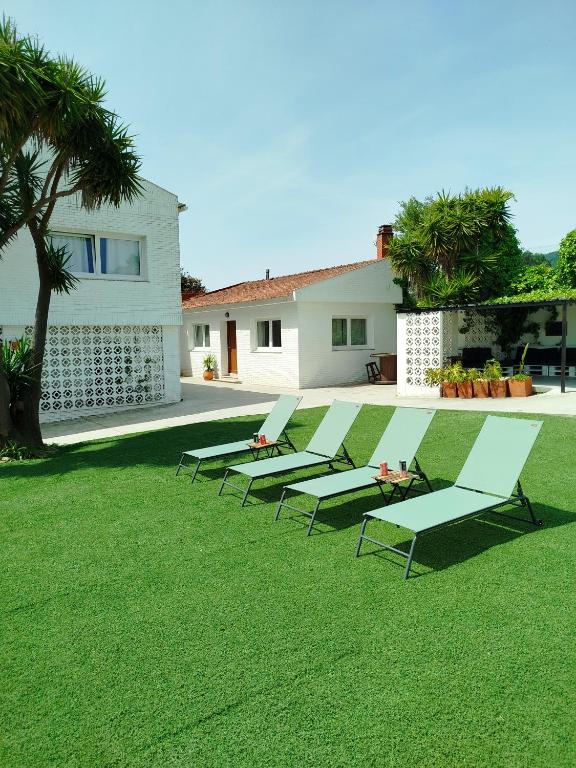 a row of chaise lounges on a lawn at La de Simón in A Guarda