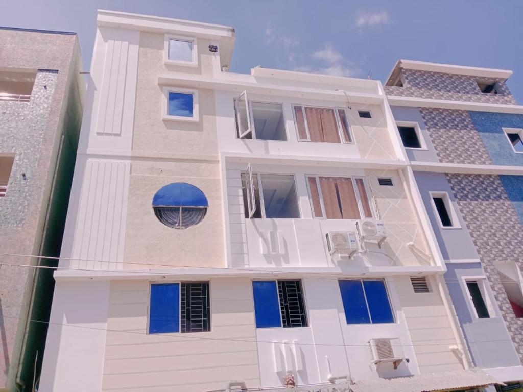 a white building with blue windows and a blue dome at GM Residency in Velankanni