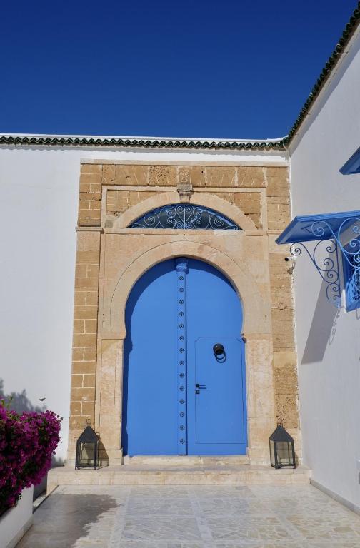 a blue door in a building with a brick wall at Dar Said in Sidi Bou Saïd