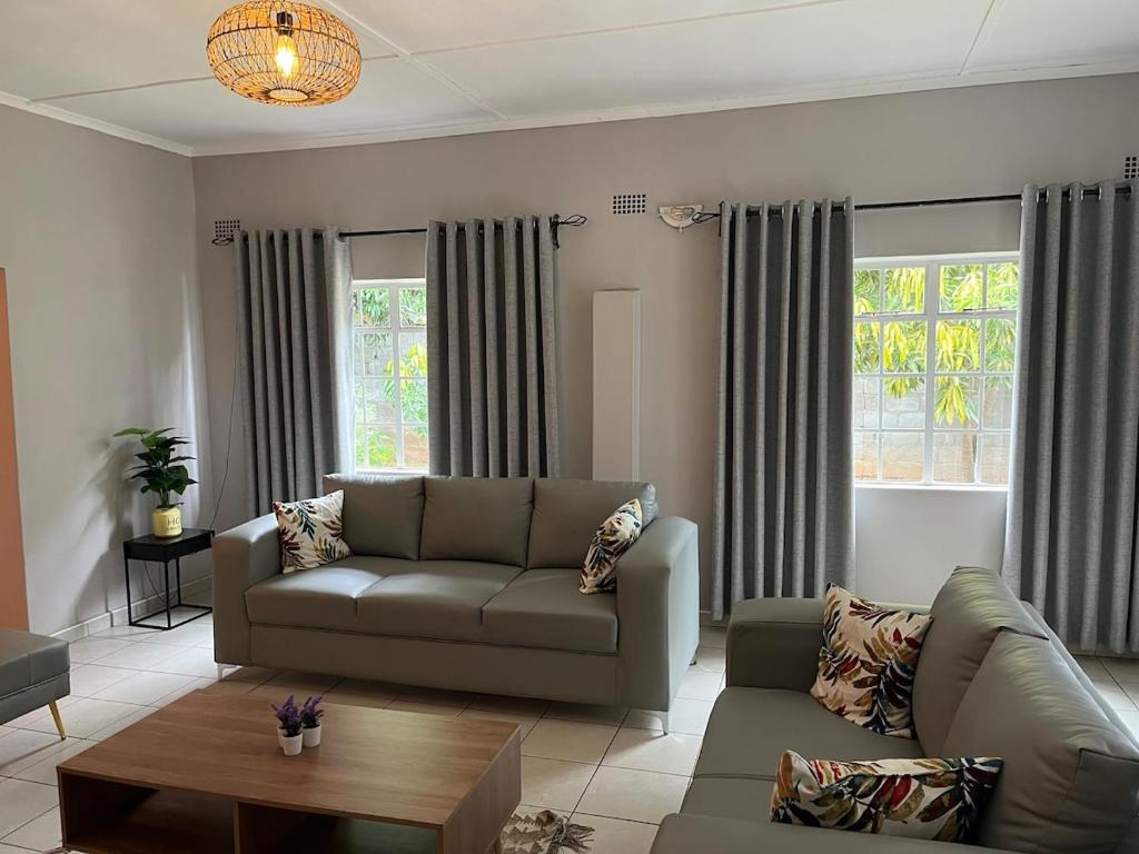 a living room with a couch and a table at Hungwe House in Victoria Falls