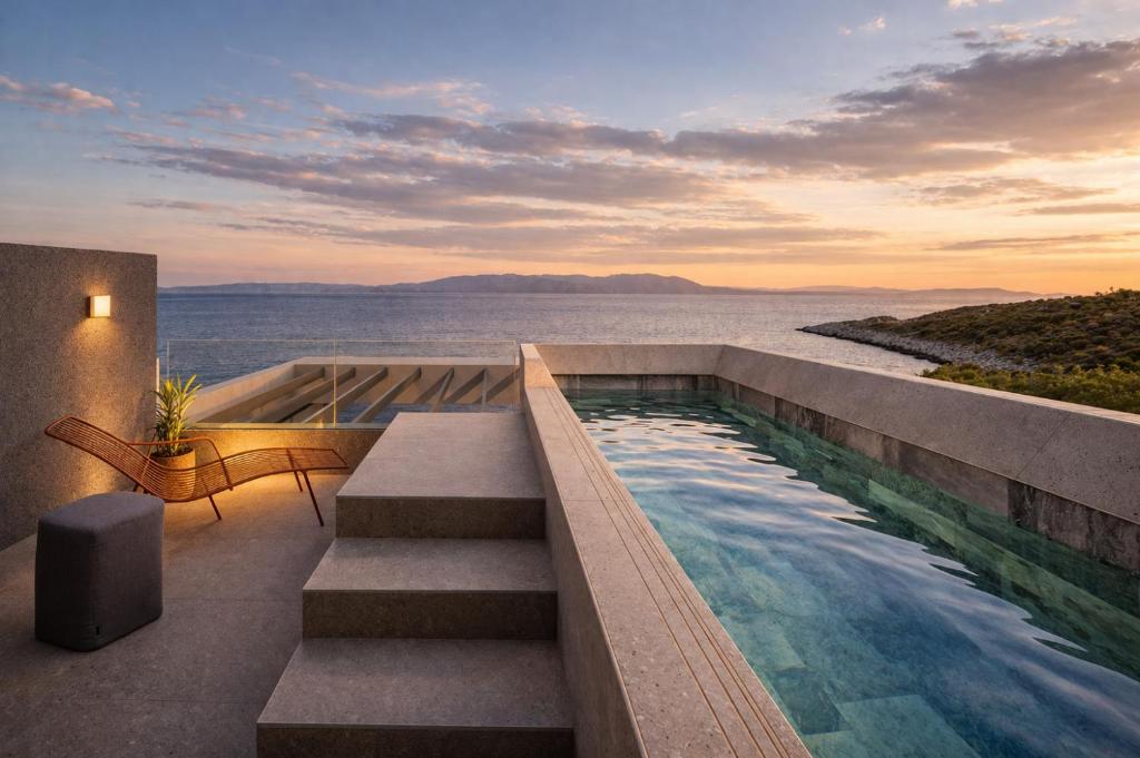 a pool with stairs and a view of the water at Nerea Residences in Schinias