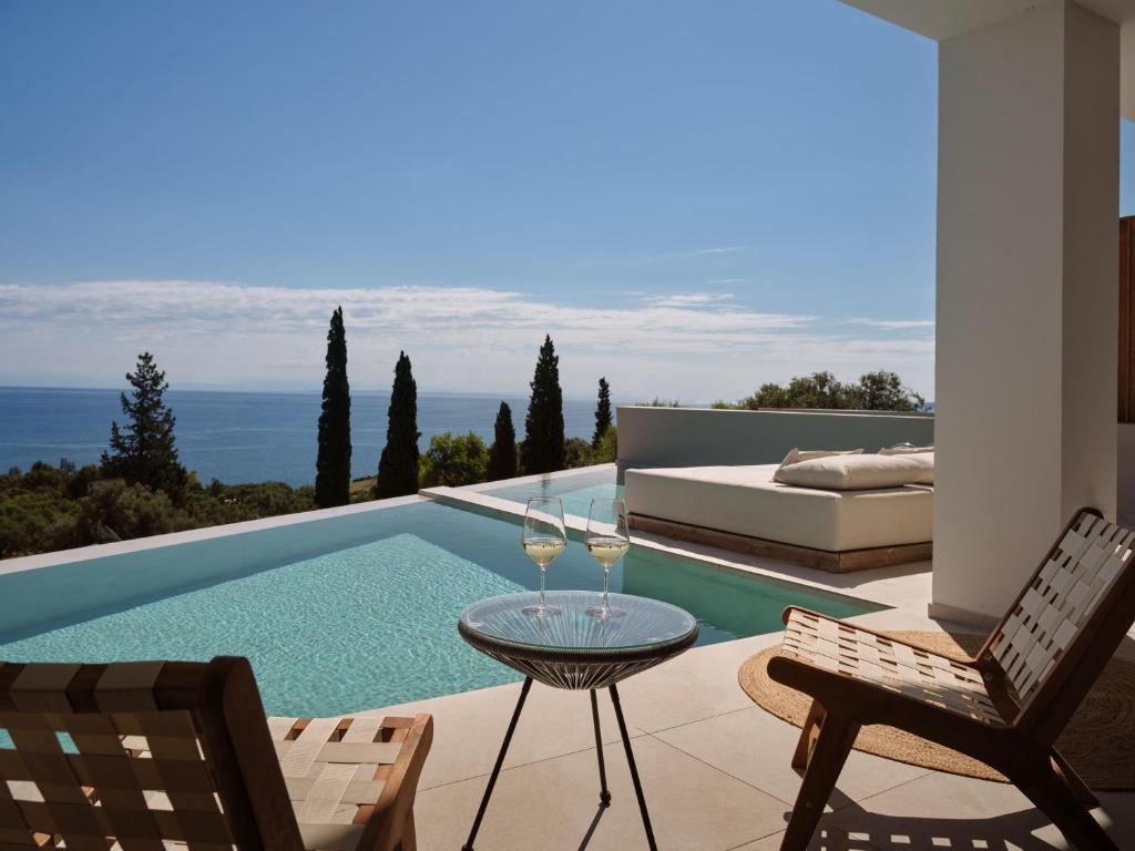 eine Terrasse mit Tisch und Stühlen und ein Swimmingpool in der Unterkunft The Sall Complex B - Sea View Suites, by ZanteWize in Agios Nikolaos