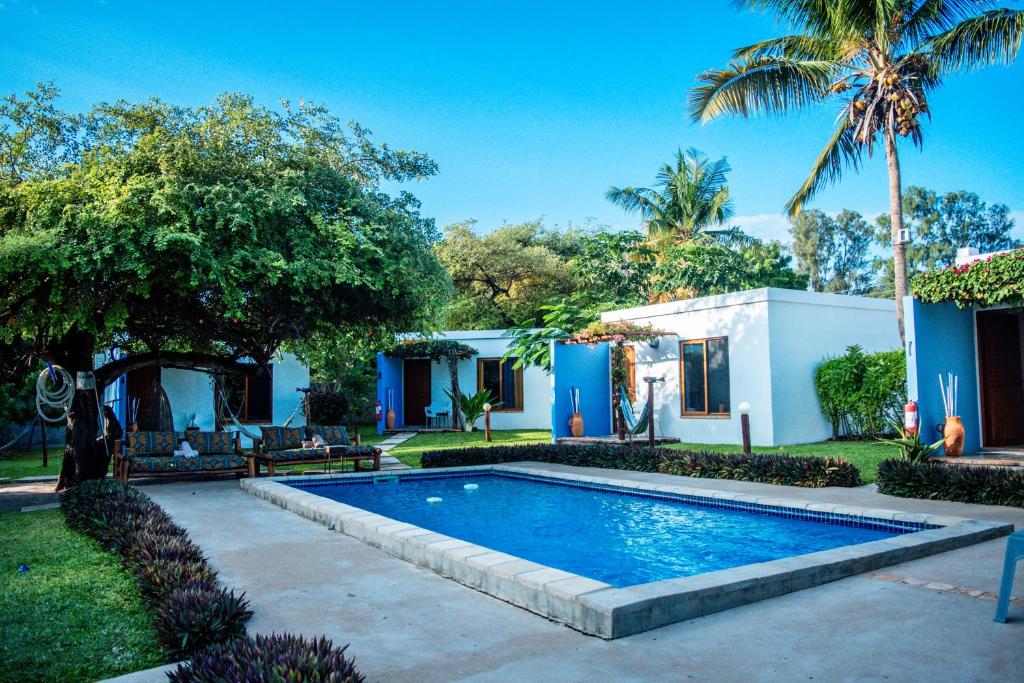 a swimming pool in a yard next to a house at Telvina Beach Lodge in Vilanculos