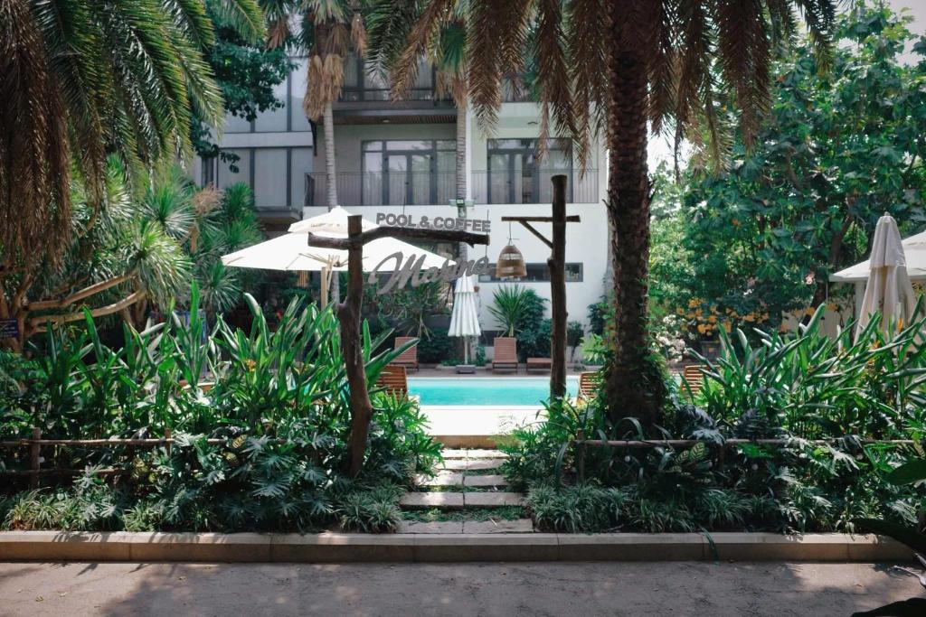 a resort with a swimming pool and a house with trees at Marina Bến Du Thuyền in Ấp Long Ðại