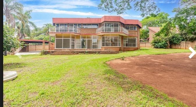 a large house with a yard in front of it at Elikia in Pretoria