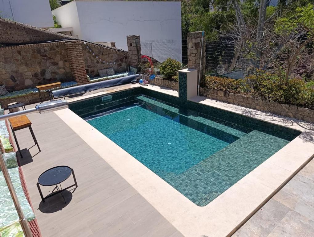 a swimming pool in the middle of a yard at Relax Ferrandiz in Málaga