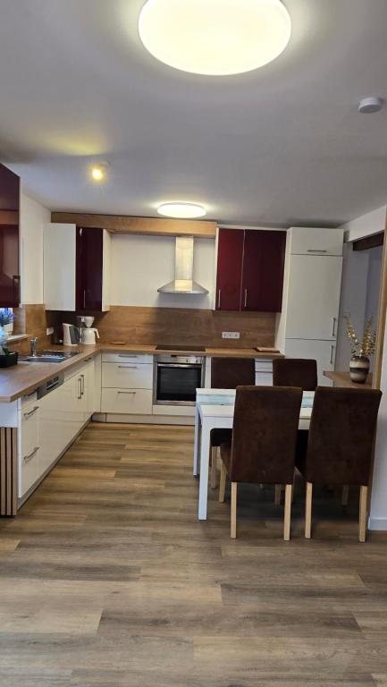 a large kitchen with a table and chairs in it at Ferienwohnung Regina in Undenheim