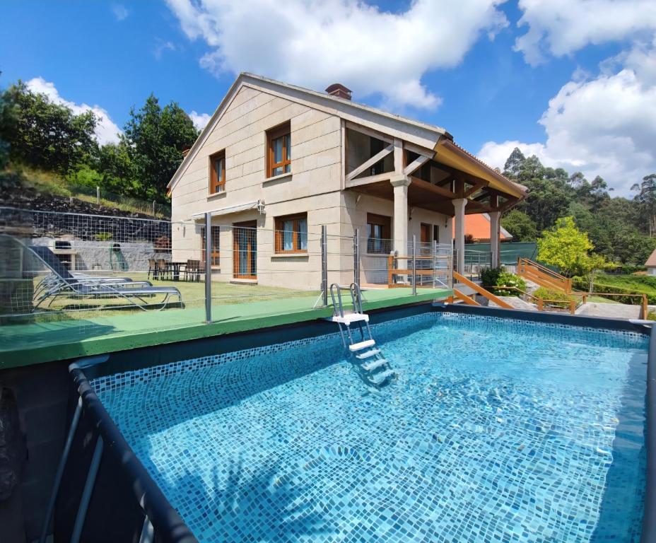 a villa with a swimming pool and a house at Casa Baixo O Castelo in Puente Caldelas