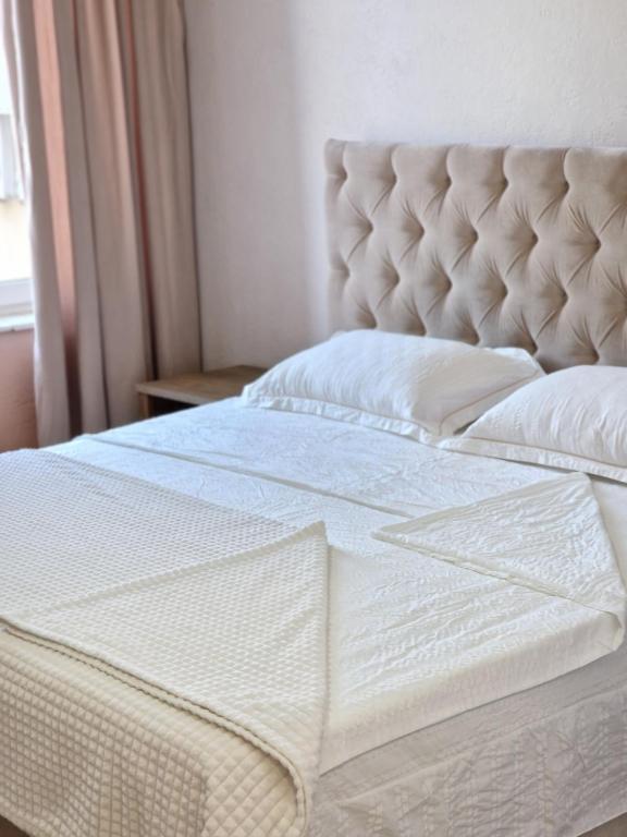 a bedroom with a bed with a tufted headboard at Silver room 3 in Zatoka