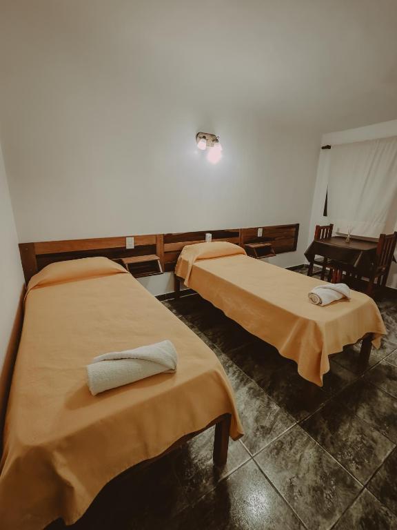 two beds sitting in a room with at Piedra Alta Hotel & Restaurante in Itá Ibaté