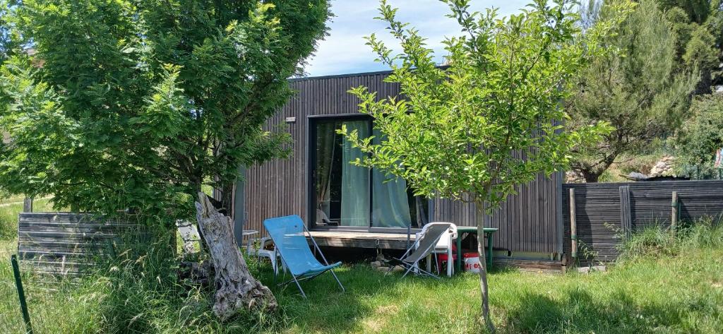 a tiny house with two chairs and a table and a tree at Studio clim 4-5 pers animaux, mai oct spa et piscine in Saint-Ambroix