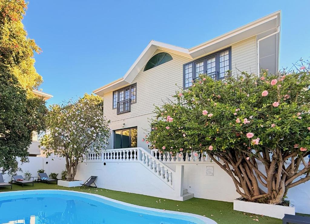 a house with a swimming pool and trees at Palm Paradise - Boutique Guest House in Cape Town