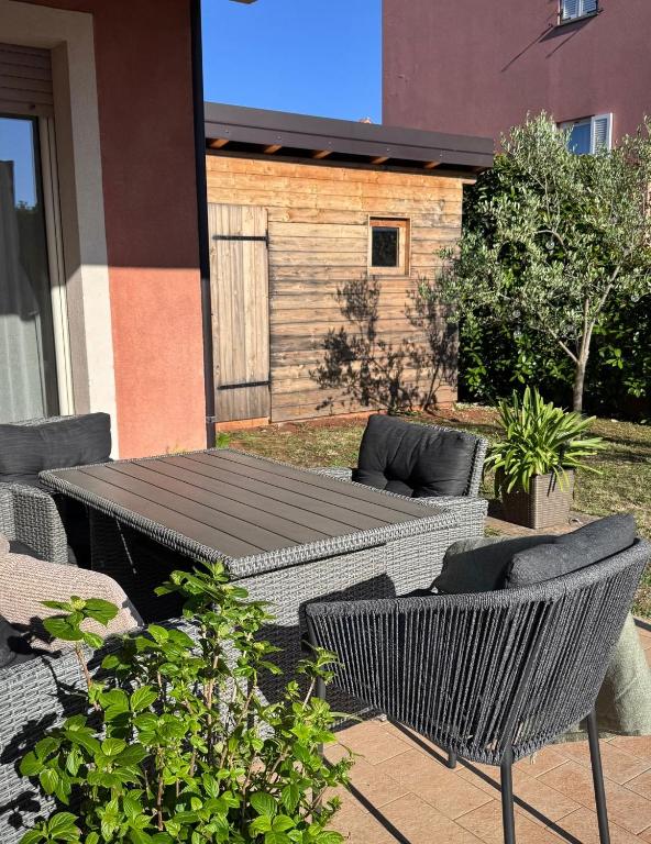 a patio with a table and chairs in a yard at Novigrad Garden Apartment in Novigrad Istria