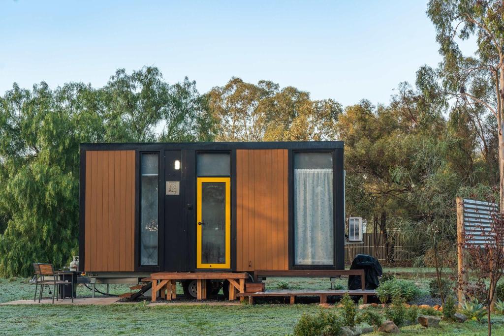 a tiny house with a table and a bench at D&L Cottage by Tiny Away in Kudla