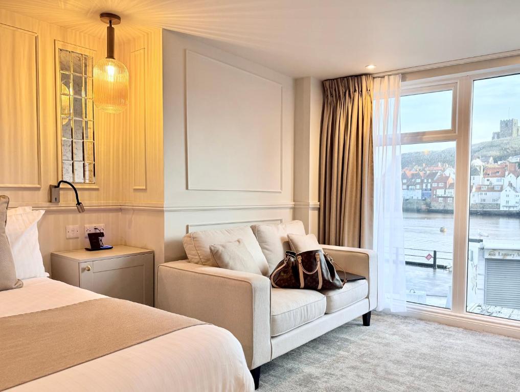 a hotel room with a bed and a window at Number 3 Pier Road Suites in Whitby