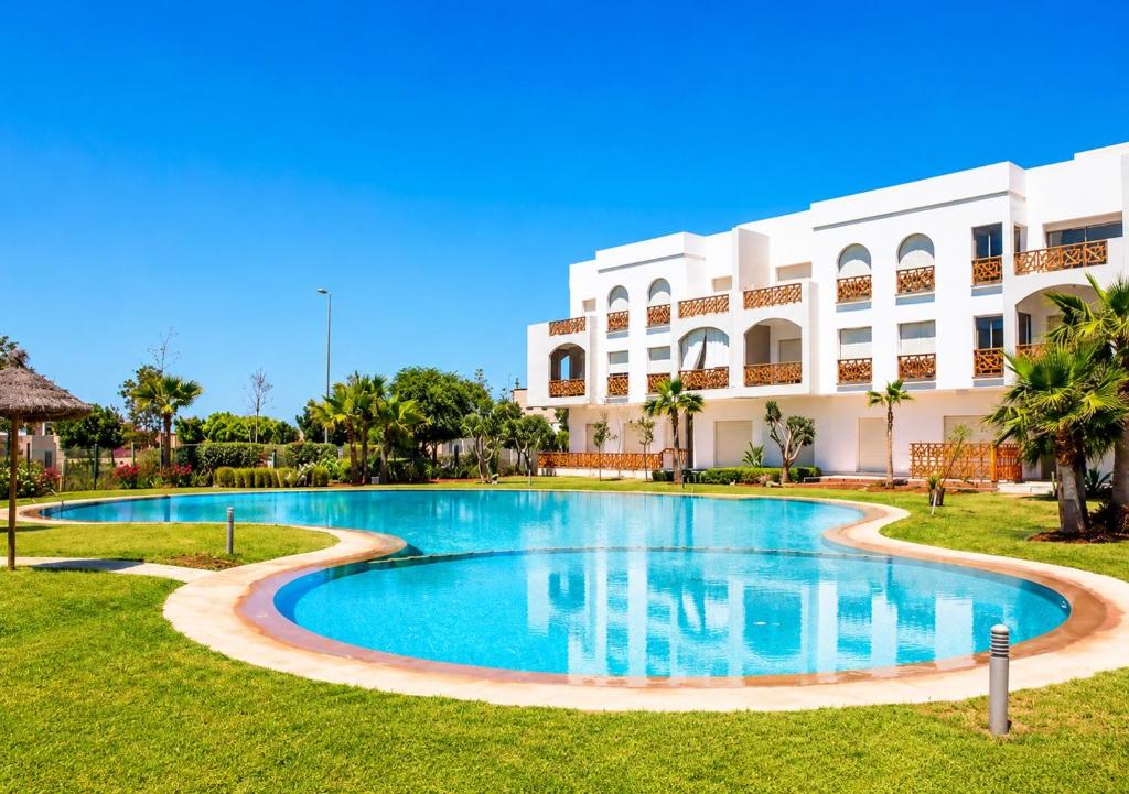 a swimming pool in front of a building at Hara Appart Luxe famille uniquement in Saïdia