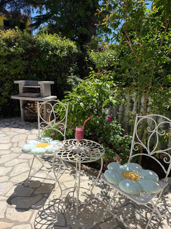 two chairs and a table in a garden at Room TARA Malinska in Malinska